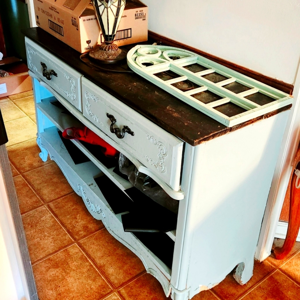 TV stand with 2 drawers and an open bottom a pretty light blue with dark wood to